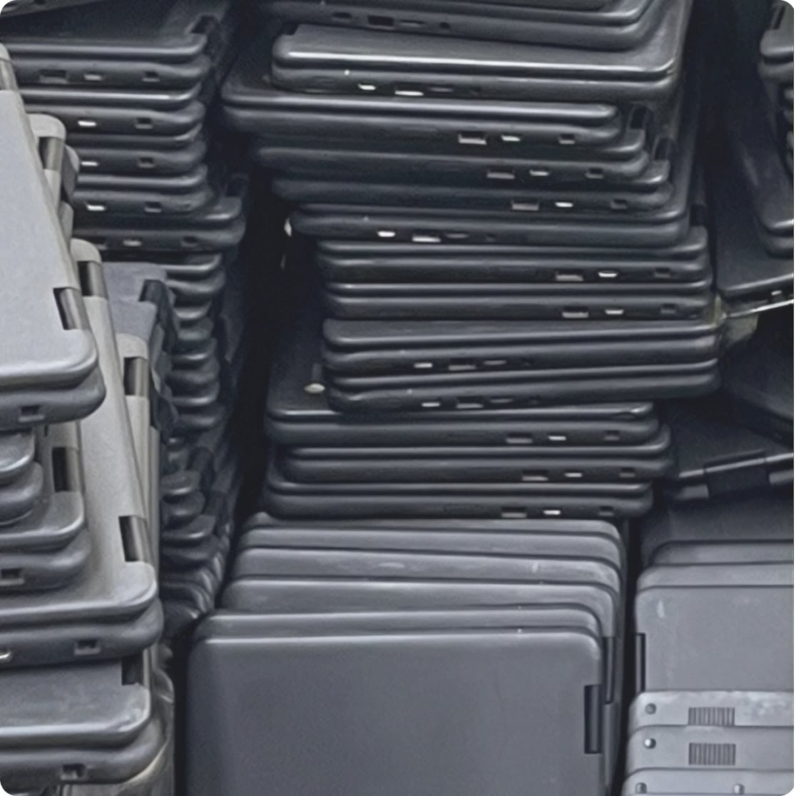 Multiple black hard-sided luggage suitcases stacked closely together in rows.