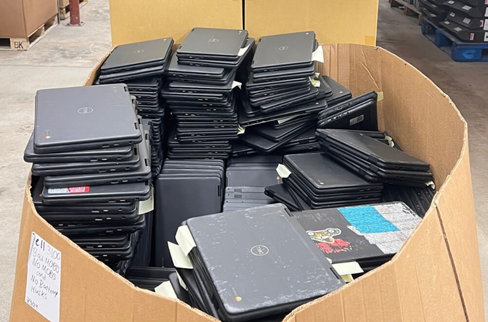 old laptops piled up in a box