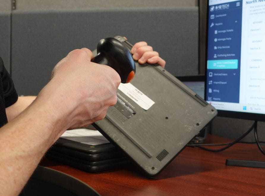man scanning bar code on laptop