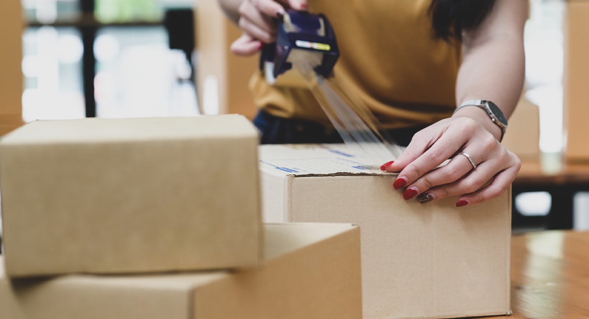 close-up of woman taping box up