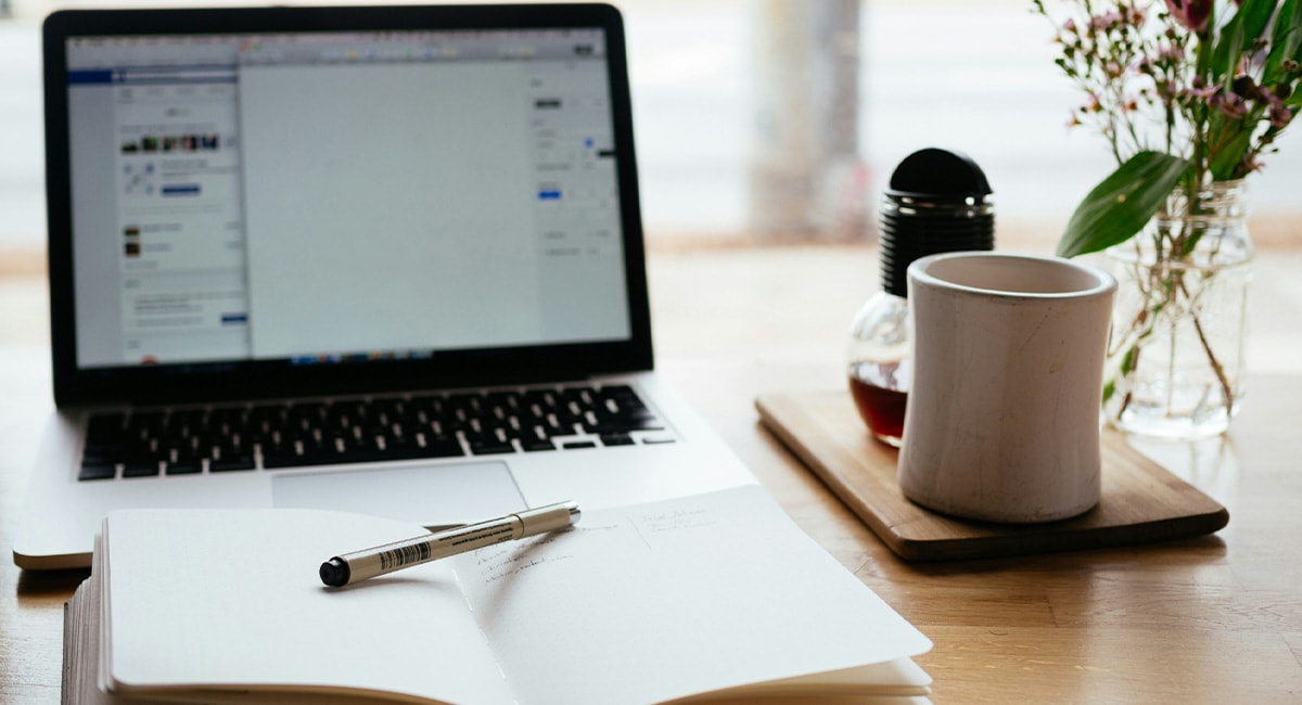 close-up of computer and notebook on desk